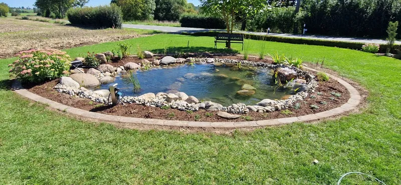 Angelegter Gartenteich mit Natursteinrand